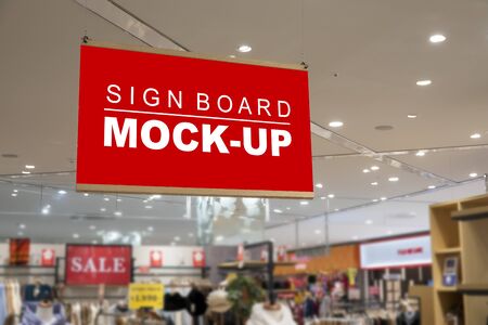 Mock up blank signboard with clipping path hanging from ceiling in clothing store, blurred background, empty space for insert advertising or announcement information promotionの写真素材