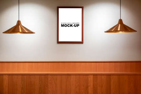 Mock up blank signboard with wooden frame  hanging on brick wall at hotel, empty space for insert text or graphic designの写真素材