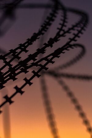 Silhouette Razor Barbed Tape Wire And light in the evening.