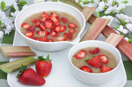 rhubarb compote with strawberries in a bowl with decorations on a tableの写真素材