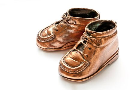 Babyshoes in bronze, on white backgroundの写真素材