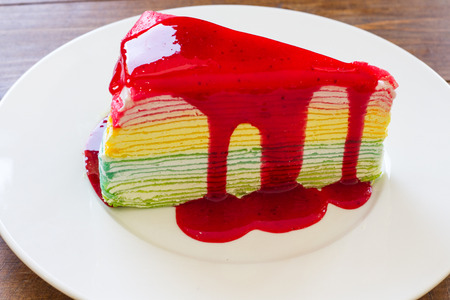 Rainbow crepe cake on wood backgroundの写真素材