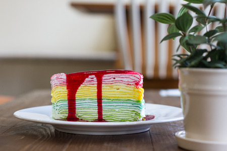 Rainbow crepe cake on wood backgroundの写真素材