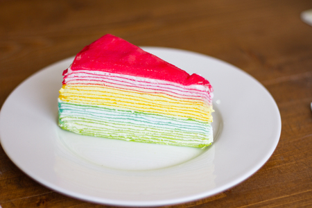 Rainbow crepe cake on wood backgroundの写真素材