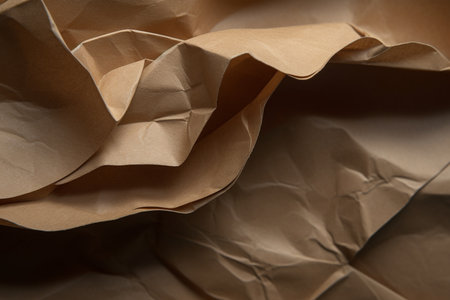 Close-up of crumpled brown paper as background texture.の素材
