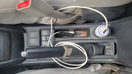 Close-up of a power supply plugged into a car's batteryの写真素材