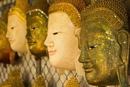 Handcrafted wooden buddha face in thai templeの写真素材