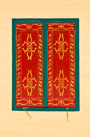 Pattern in traditional Thai style art painting on window of the church in thai templeの写真素材