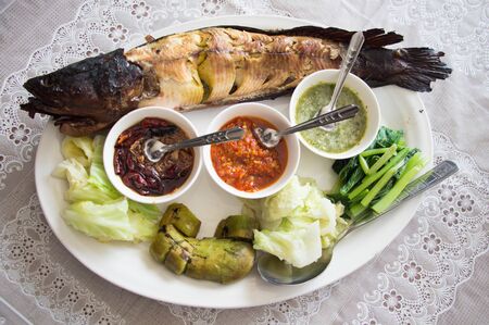 Thai fish grilled served with fresh vegetable and special sauce, (Miang pla chon)の写真素材