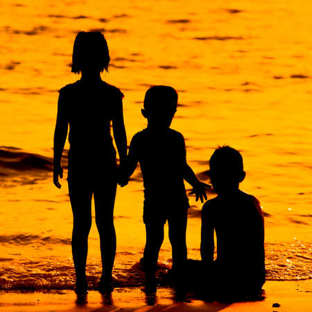 Silhouette  little  child on a beach at sunset