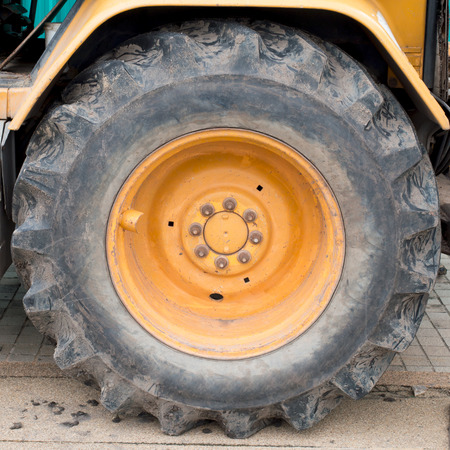 big wheel on yellow tractorの写真素材