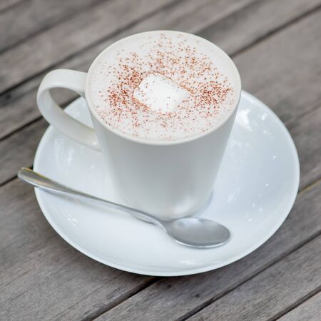 Hot chocolate in a white cup on tableの写真素材