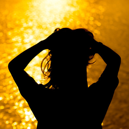 Silhouette of Woman's at Sunsetの写真素材