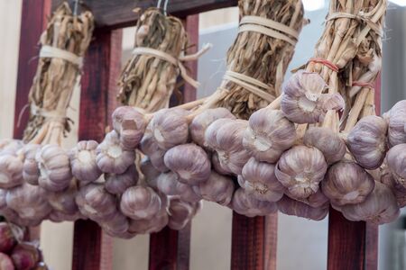 Shallot bunch hanging on a wooden wallの写真素材