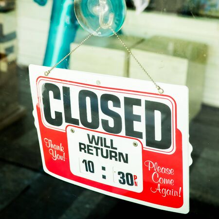 Vintage retro looking Closed sign in a shop showroom with reflectionsの写真素材