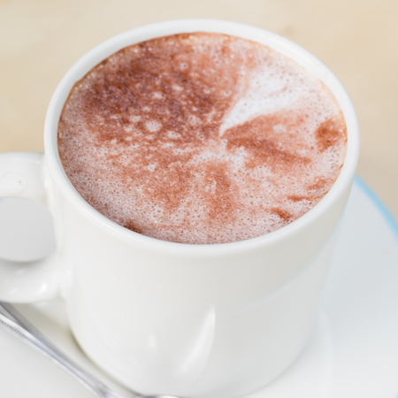 Hot chocolate in a white cup on tableの写真素材