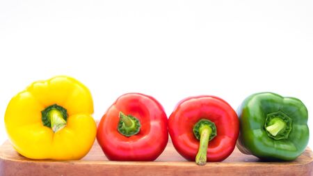 Fresh organic bell peppers on a wooden boardの写真素材