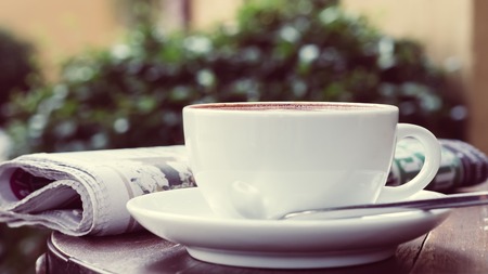 A cup of coffee on the table with newspaperの写真素材