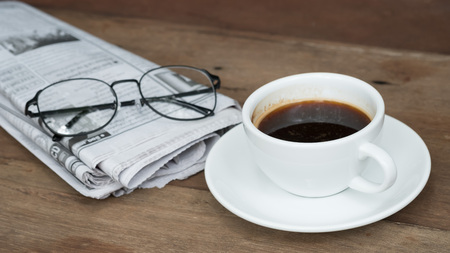 A cup of coffee on the table with newspaperの写真素材