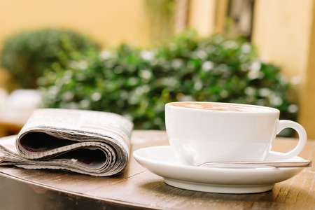 A cup of coffee on the table with newspaperの写真素材