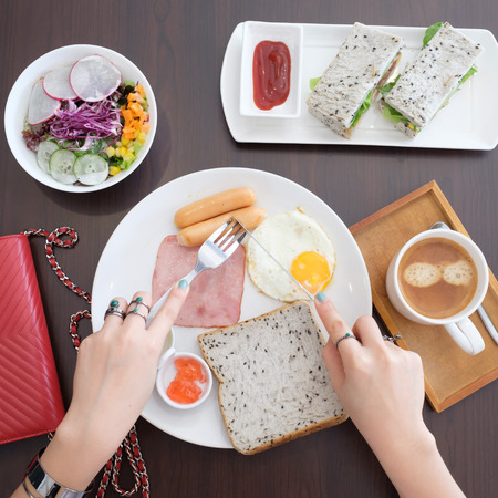 Woman having breakfast top viewの写真素材