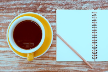 still life with notebook , pencil and cup of coffee on table - vintage filterの写真素材