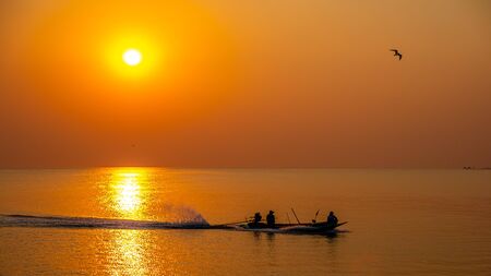 Silhouettes people on the long tail boatの写真素材