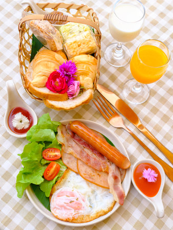 American breakfast with eggs,bread, bacon,milk, coffee and orange juiceの写真素材