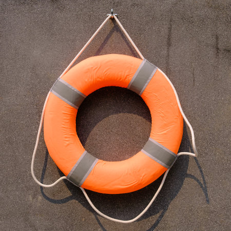Orange lifebuoy on cement  backgroundの写真素材
