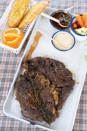 grilled beef steaks with cream source on white plateの写真素材