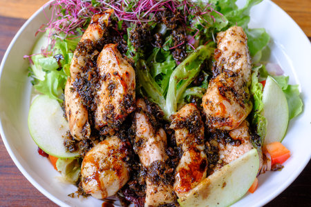 Chicken salad  with vegetables and apple on white plateの写真素材