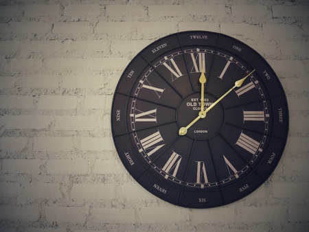 Antique clock retro style hanging on white brick wall
