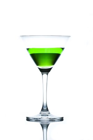 Green drinks in martini glass on white background with reflectionの写真素材