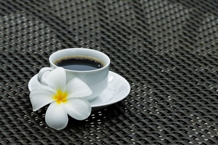Black coffee with plumeria flowerの写真素材