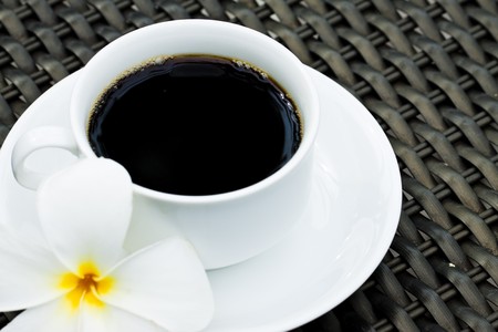 Black coffee with plumeria flowerの写真素材