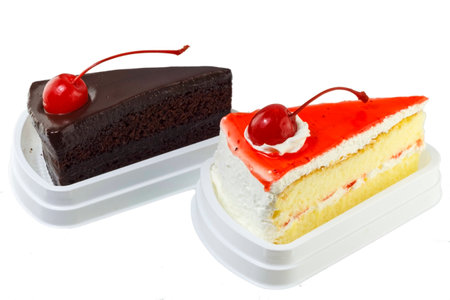 Piece of strawberry cake and chocolate cake with cherry on white background の写真素材