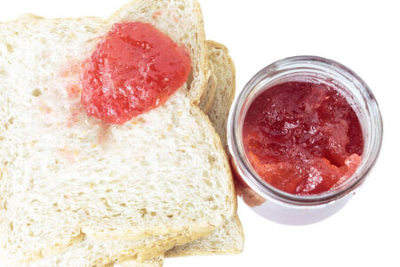 Closeup pile of sliced bread with strawberry jam on white background.の写真素材