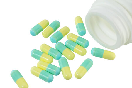 Pills Capsule, Herb capsule spilling out of a bottle on white background.の写真素材