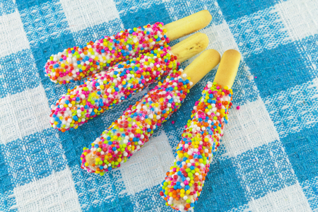 Closeup of many small decorative pieces of colorful sugar sweets on cookiesの写真素材