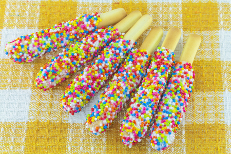 Closeup of many small decorative pieces of colorful sugar sweets on cookiesの写真素材