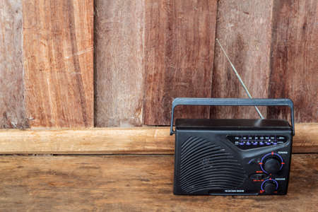 Vintage radio receiver device on wooden background.の写真素材