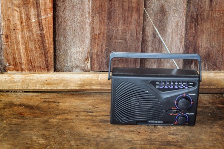 Vintage radio receiver device on wooden background.の写真素材