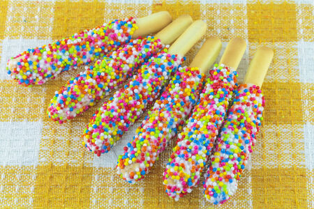 Closeup of many small decorative pieces of colorful sugar sweets on cookiesの写真素材