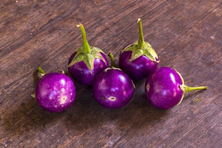 Purple Eggplant. Fresh purple eggplants on a wooden backgroundの写真素材