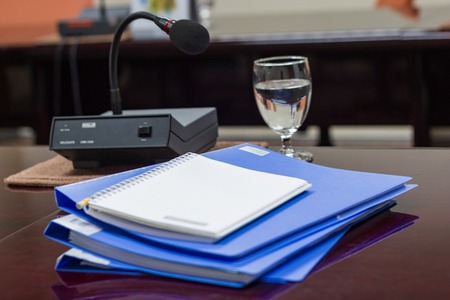 blue files folder retention of contracts, note paper and Glass on brown desk in the conference room