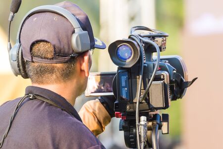 professional cameraman - covering an event to a live and record video at outdoorの写真素材