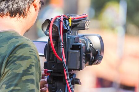 professional cameraman - covering an event to a live and record video at outdoor