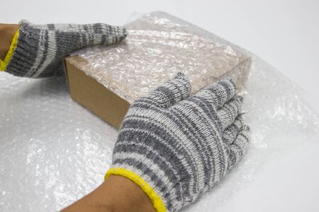 Man handles bubble wrap to protect productsの写真素材
