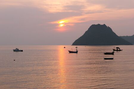 Sea View Landscape the ocean and boat at sunrise time orange color and mountains on the horizon at Ao Manow Prachuap Khiri Khan, Thailandの写真素材