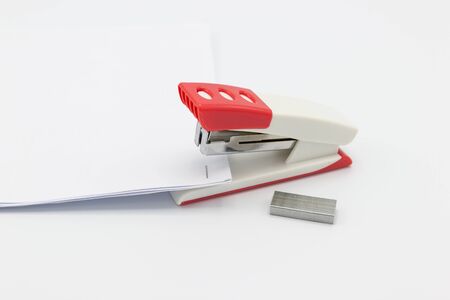 Pink stapler and paper document on white background, Office equipment.の写真素材